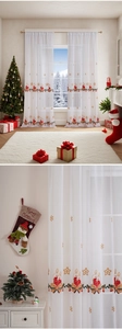Detail der Weihnachtskerzen-Stickerei und goldener Schneeflocken auf weißem, transparentem Vorhang