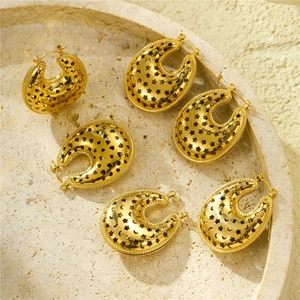 Gold U-shaped hoop earrings with hollow star and heart patterns on stone tray