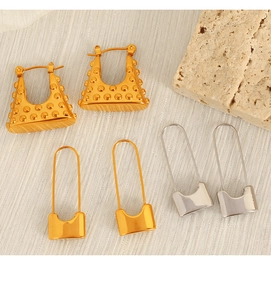 Chic gold and silver lock-shaped stud earrings set on a textured neutral stone