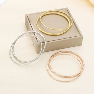 Minimalist stackable stainless steel bangles in gold, silver, and rose gold finishes