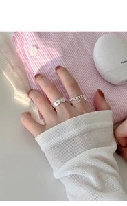Détail d'une bague en dentelle argentée et bague noeud portées par un mannequin