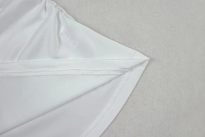 Makroaufnahme der präzisen Nähte und Saumdetails am weißen, weichen Stoffkleid
