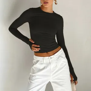Detail of slim-fit black top featuring modern thumbhole cuffs and stretch fabric