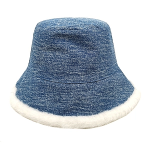 Détail d'un chapeau bob en denim bleu avec bordure épaisse en fausse fourrure blanche