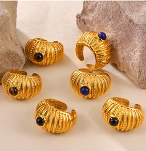 Detail of vintage gold-plated rings with lapis, tiger eye, and onyx inlays on stone