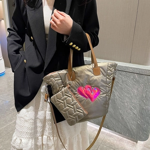 Detailansicht der silbernen Stepptasche mit rosa Herz-Patch und kleinem Münzfach