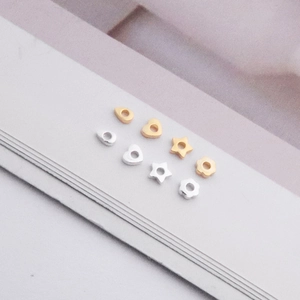 Detailed view of silver and gold beads in heart, star, and flower shapes for DIY jewelry