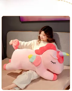 Close-up of a giant pink unicorn plush toy with colorful wings and soft mane