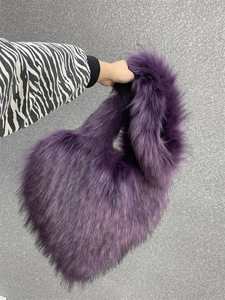 Detail view of oversized deep purple faux fur shell bag with long fluffy plush texture
