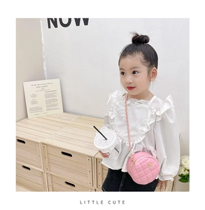 Detailed view of kids pink quilted round crossbody bag with floral buckle on a child model