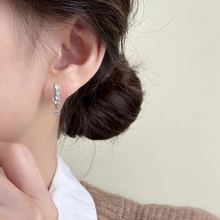 Close-up of elegant silver drop earrings with zircons on a model for daily wear