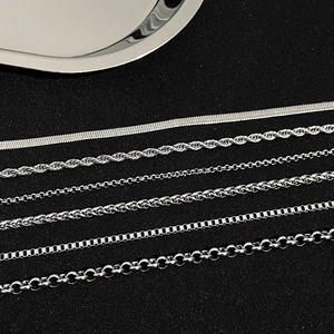 Macro view of six various polished silver steel chain styles on black background