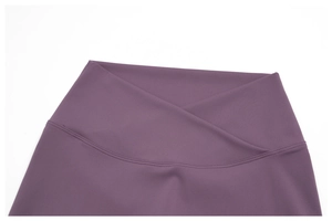 Detail of high-waist purple yoga leggings featuring a stylish cross V-neck waistband design