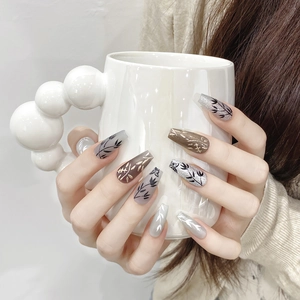 Faux ongles peints à la main avec motifs papillon et bambou sur base neutre chic