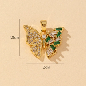 Macro shot of a 3D butterfly pendant with green and clear zircons, size 1.8cm by 2cm