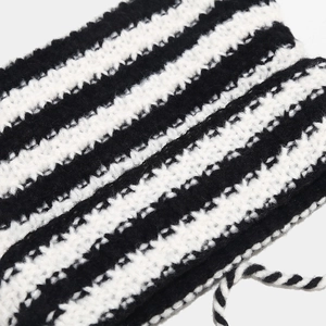 Détail macro du tricot à rayures noires et blanches et lien torsadé du bonnet chaud