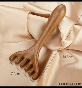 Macro detail of sandalwood scalp massage comb with 14.5cm size specifications on silk fabric