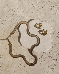 8mm gold snake chain necklace and twisted hoop earrings set on stone platform