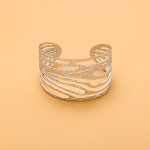 Macro view of silver stainless steel open bangle with unique textured hollow design
