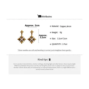 Detail view of vintage Fleur-de-lis earrings with gold-tone metal and zircon stones