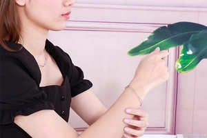 Detail of silver double-loop chain necklace and bracelet set worn by a model