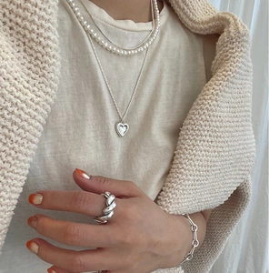 Detail of 925 sterling silver layered necklace with pearls and heart pendant