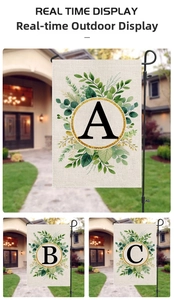 Outdoor garden flag detail showing floral alphabet designs on textured linen with metal stands