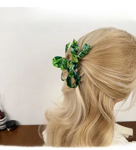 Green marble acetate hair claw clip shown on blonde wavy hair for elegant styling