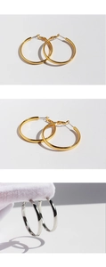 Detail of high-polished gold and silver hoop earrings showing the secure spring closure
