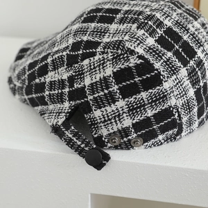 Close-up of kids tweed checkered newsboy cap with adjustable back strap and metal buttons