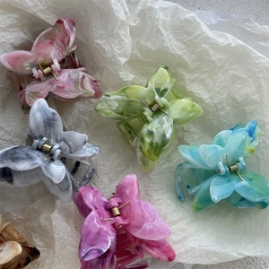 Detail of colorful butterfly hair claws with marble texture and gold metal springs