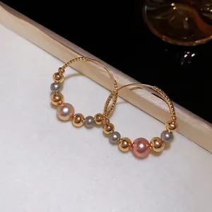 Twisted gold hoop earrings with multi-colored pearls and metallic beads for women