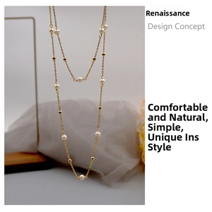 Détail d'un long collier de perles d'eau douce avec perles dorées sur chaîne en titane