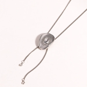 Macro detail of silver bolo tie necklace with oval metal slider and zircon pendants