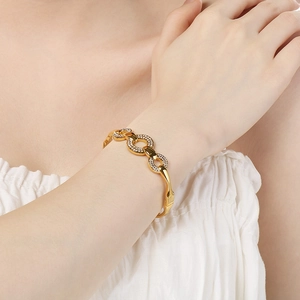 Detail of a gold interlocking chain bracelet with sparkling pavé cubic zirconia