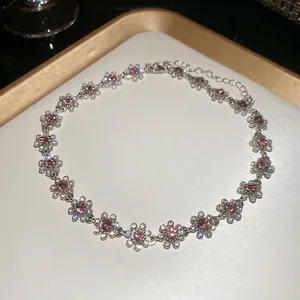 Elegant silver flower necklace with pink gemstones and crystals on a white jewelry tray