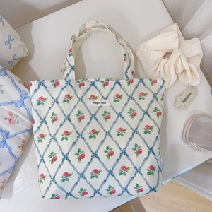 Detailed view of floral canvas tote bag featuring pink roses and simple wish label