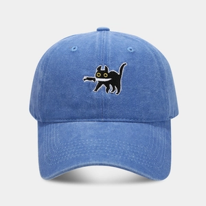 Close-up of black cat embroidery on a blue washed cotton baseball cap with rich texture