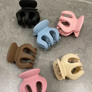 Flat lay of pastel matte tulip hair clips in various macaron colors on stone surface