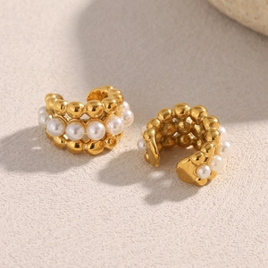 Macro shot of 18K gold plated beaded earrings with white pearls in a layered hoop design