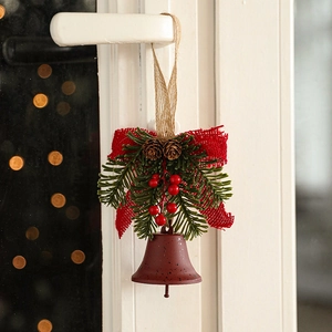 Christmas iron bell pendant with red bow, pine cones and berries on a door handle