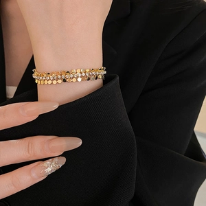 Détail d'un bracelet triple rang doré avec paillettes et oxydes de zirconium