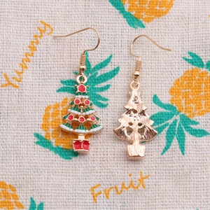Detail view of colorful enamel Christmas tree earrings with gold-tone hooks and textured back
