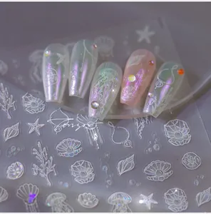 Macro detail of 3D shell and jellyfish nail art stickers on long false nails