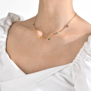 Close-up of 18K gold plated necklace featuring vibrant multicolor gemstone charms on a thin chain
