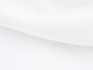 Detailed close-up showing soft white fabric texture and elegant draping of the dress