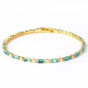 Details eines goldenen Tennisarmbands mit blauen Rechtecksteinen und weißen Zirkonia