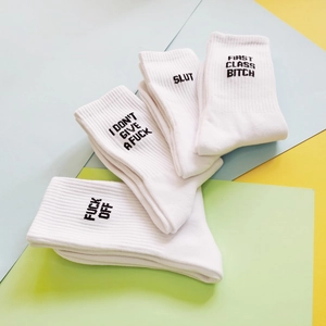 White ribbed cotton crew socks featuring bold black embroidered FUCK OFF lettering
