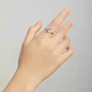 925 sterling silver hugging hands open ring for women on a model hand with soft lighting