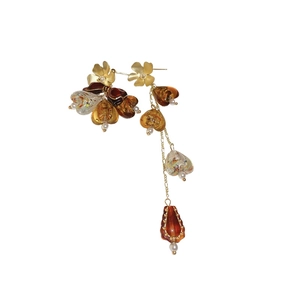 Boucles d'oreilles asymétriques à fleurs avec cœurs ambre et perles sur fond blanc
